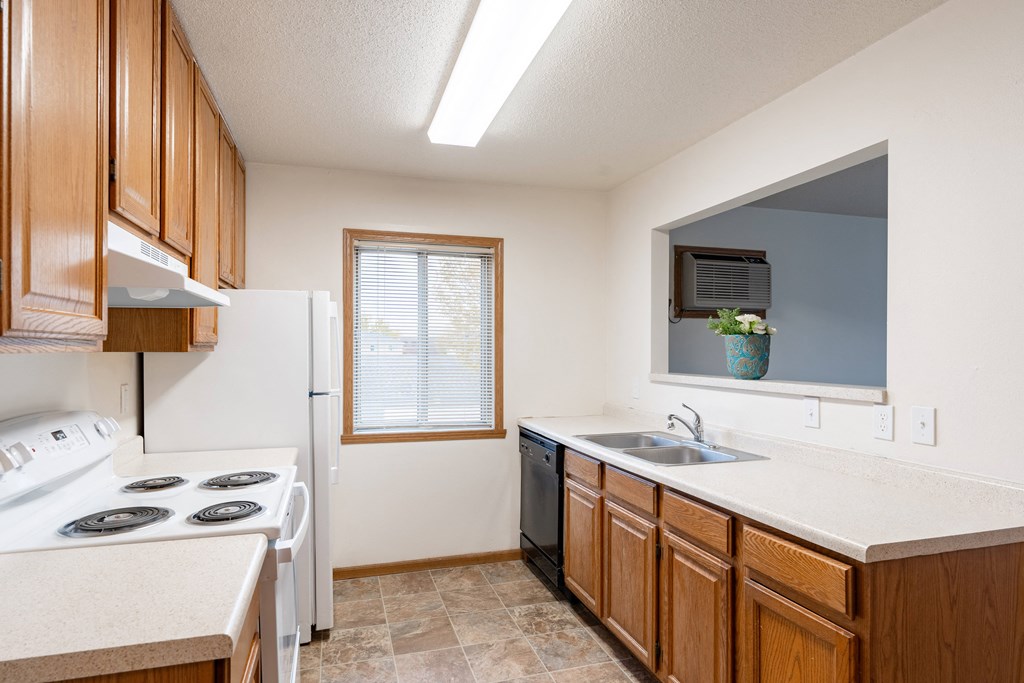 a kitchen with a stove sink and a refrigerator. Fargo, ND Oxford Apartments
