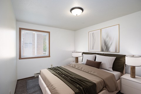 a bedroom with a large bed and a window. Fargo, ND Pacific Park 2 Apartments