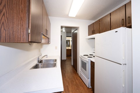 a kitchen with white appliances and wooden cabinets and a white refrigerator