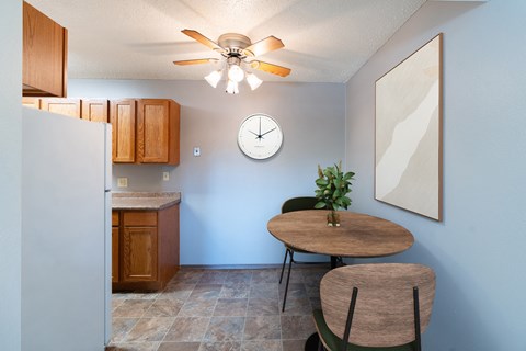 a dining room with a table and a clock on the wall. Fargo, ND Pacific Park Apartments