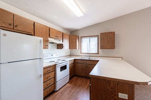 an updated kitchen with white appliances and wooden cabinets