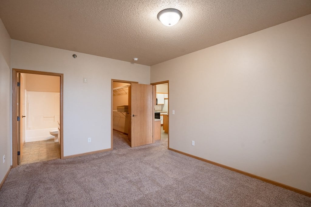 a bedroom with a walk in closet and a bathroom. Fargo, ND West Lake Apartments