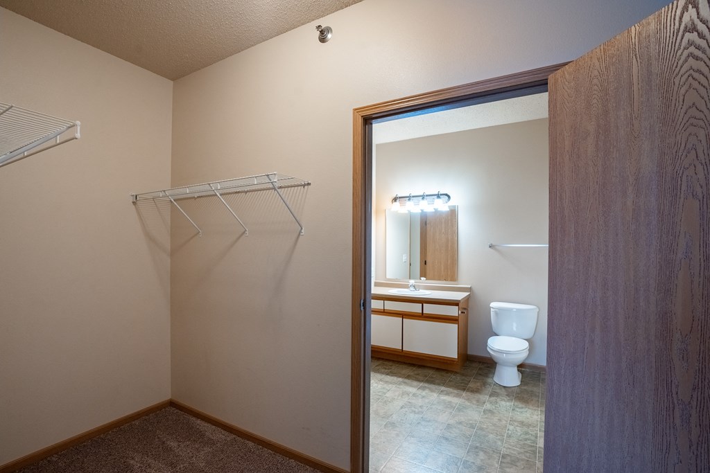 an empty bathroom with a shower and a toilet. Fargo, ND West Lake Apartments