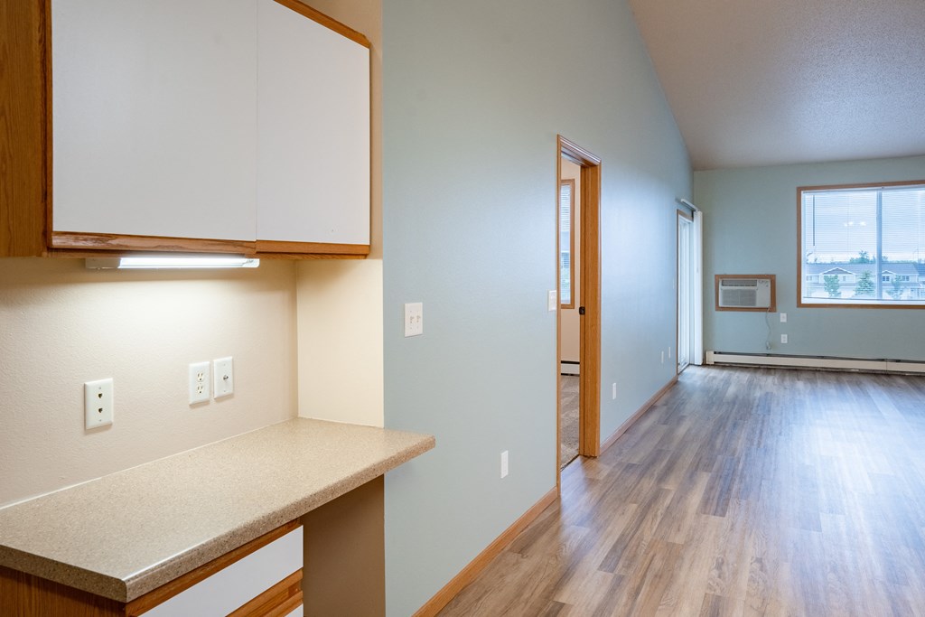 the living room and kitchen of an empty apartment. Fargo, ND West Lake Apartments