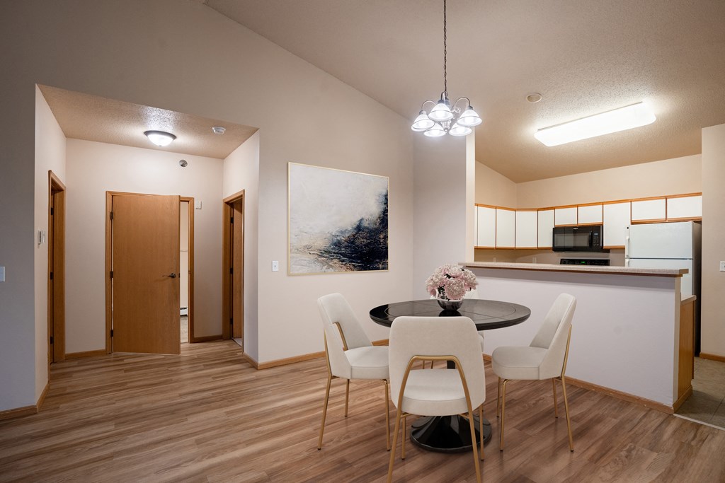 Fargo, ND West Lake Apartments | Dining a dining room with a table and chairs and a kitchen. Fargo, ND West Lake Apartments