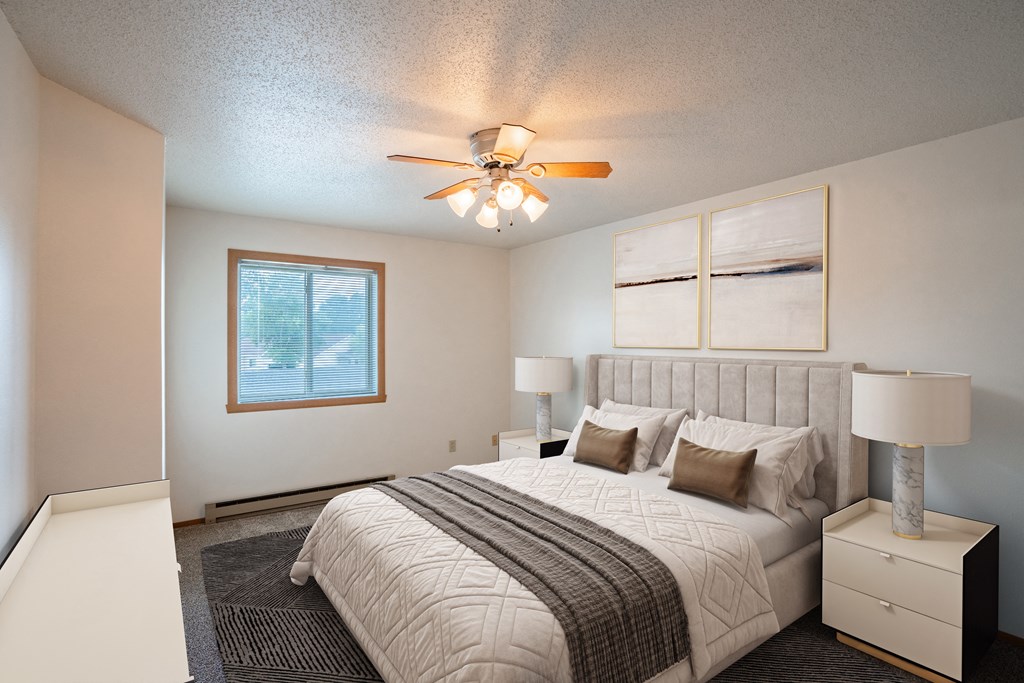 the master bedroom has a large bed and a ceiling fan. Fargo, ND Westview Towers Apartments