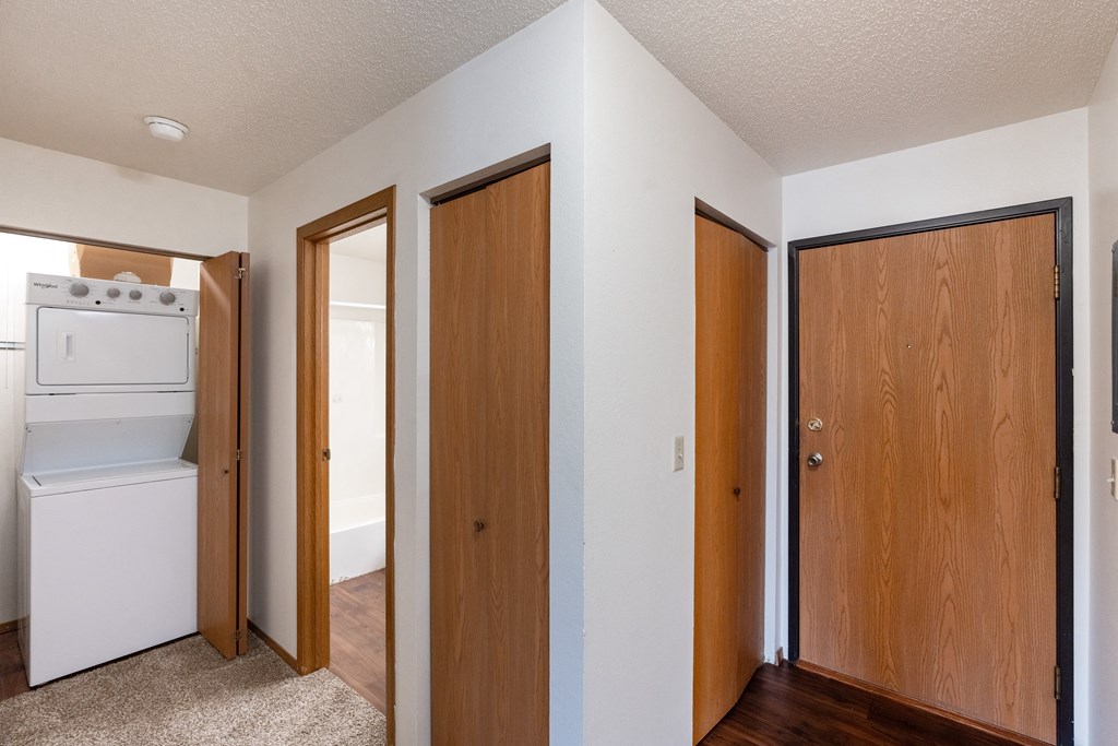 an empty room with three doors and a laundry room. Fargo, ND Westview Towers Apartments