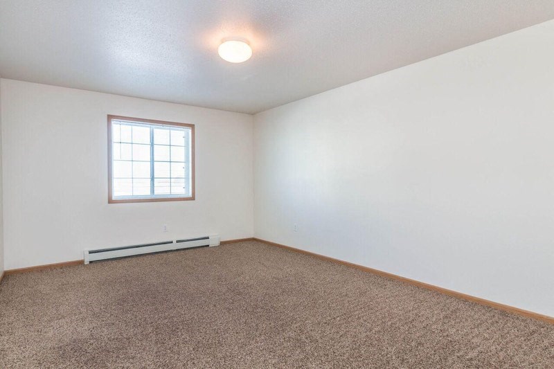 a living room with a window and carpet. Fargo, ND Foxtail Townhomes