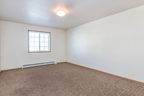 a living room with a window and carpet. Fargo, ND Foxtail Townhomes