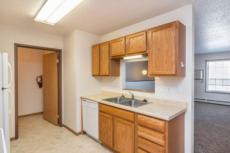 a kitchen with a sink and wooden cabinets. Fargo, ND Foxtail Townhomes