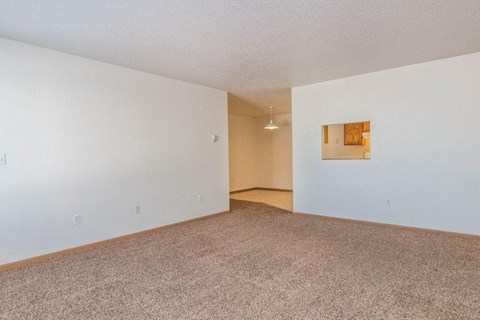 Fargo, ND Foxtail Townhomes | Living an empty living room with white walls and carpet. Fargo, ND Foxtail Townhomes