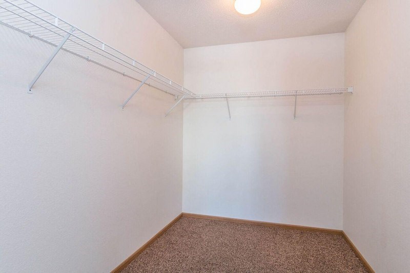 a closet with a white wall and a wire rack on the wall. Fargo, ND Foxtail Townhomes