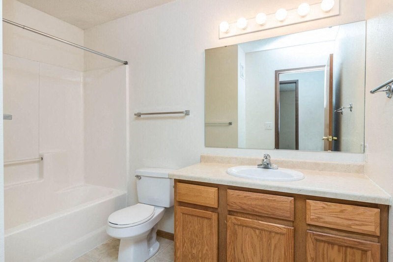 a bathroom with a sink toilet and a mirror. Fargo, ND Foxtail Townhomes