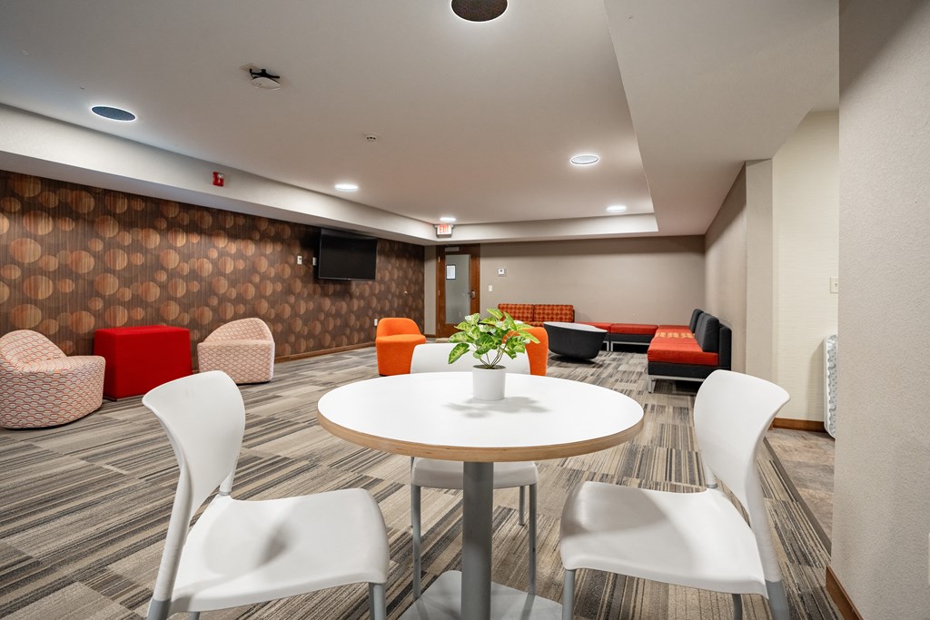 a meeting room with a round table and chairs. Fridley, MN Georgetown on the River Apartments
