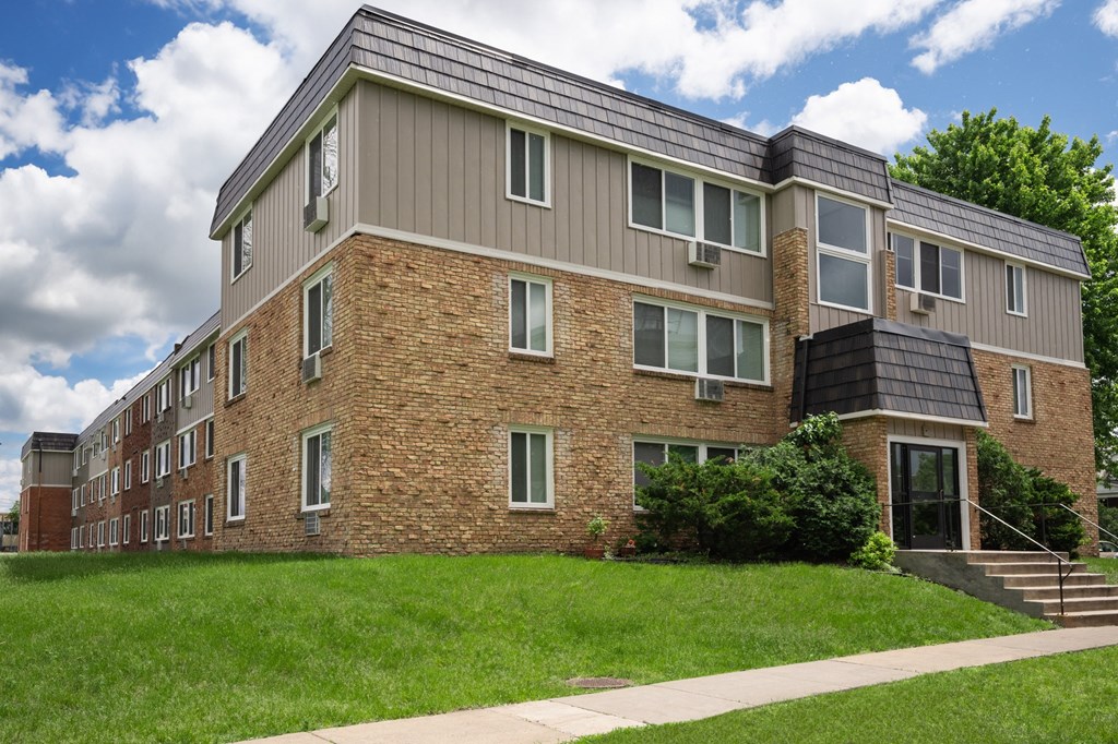 a brick apartment building with a solar roof on top of it. Fridley, MN Georgetown on the River Apartments