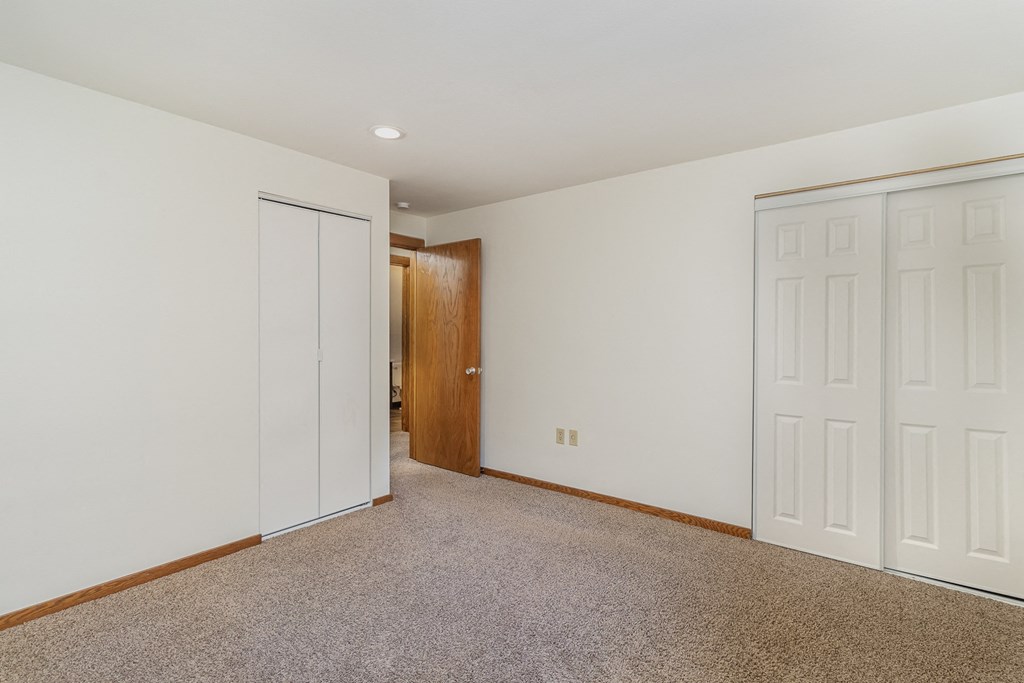 a bedroom with two closets and a door to a hallway.  Golden Valley, MN Valley View Apartments