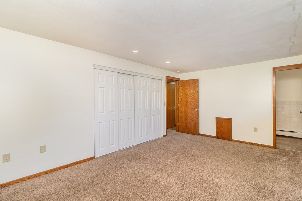 a bedroom with a large closet and door to a hallway.  Golden Valley, MN Valley View Apartments