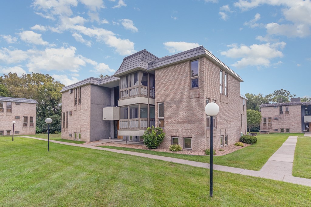 a brick apartment building with a green lawn and sidewalk.  Golden Valley, MN Valley View Apartments