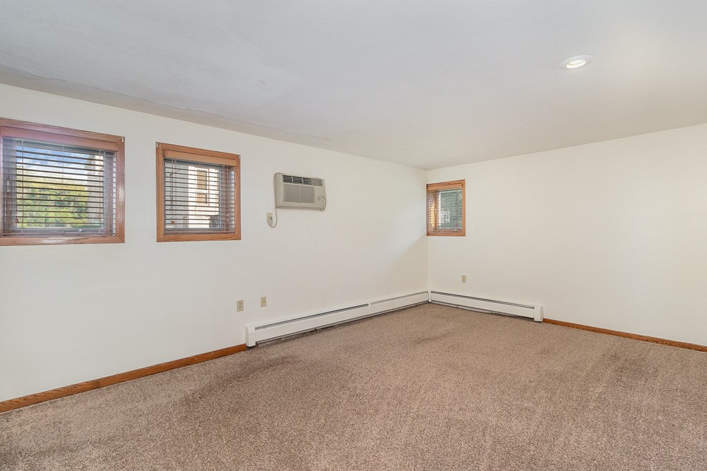 a bedroom with carpet and two windows.  Golden Valley, MN Valley View Apartments