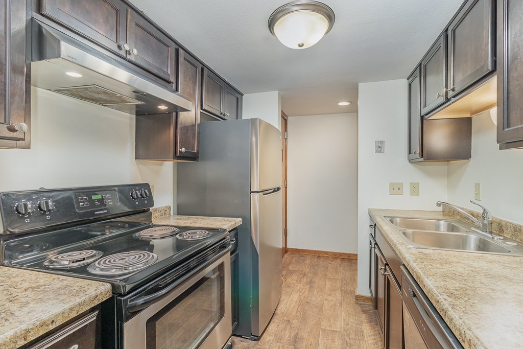 an empty kitchen with stainless steel appliances and granite counter tops.  Golden Valley, MN Valley View Apartments