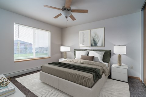 a spacious bedroom with a ceiling fan and a bed. Grand Forks Desoto Estates
