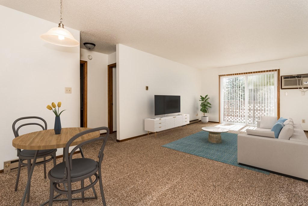 Grand Forks, ND Autumn Apartments | Living and dining Grand Forks, ND Autumn Apartments a living room with a table and chairs and a television on the wall