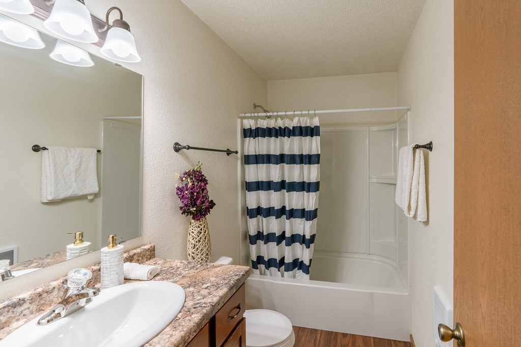 Grand Forks, ND Autumn Apartments. A bathroom with a sink, toilet, and a bathtub.