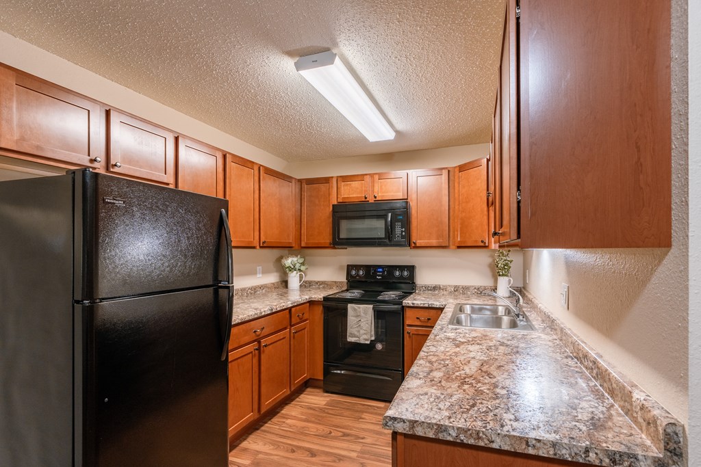 Grand Forks, ND Autumn Apartments. A kitchen with black appliances.