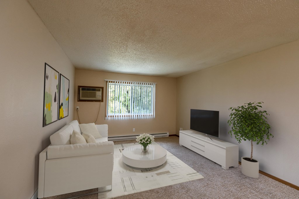 a living room with a couch and a coffee table and a tv. Grand Forks, ND Autumn Apartments.