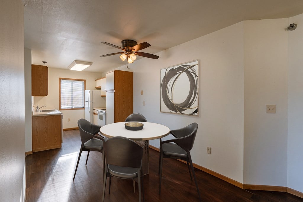 Grand Forks, ND Autumn Ridge Apartments | Dining a dining area with a table and chairs and a ceiling fan. Grand Forks, ND Autumn Ridge Apartments
