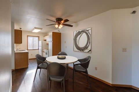 a dining area with a table and chairs and a ceiling fan. Grand Forks, ND Autumn Ridge Apartments