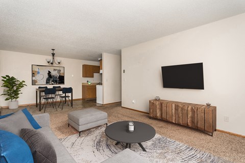 Grand Forks, ND Barrette Arms Apartments. a living room with a couch a table and a chair and a television on the wall