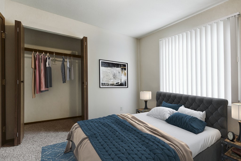 Grand Forks, ND Carling Manor Apartments. a bedroom with a large bed and a closet with a sliding door and a window