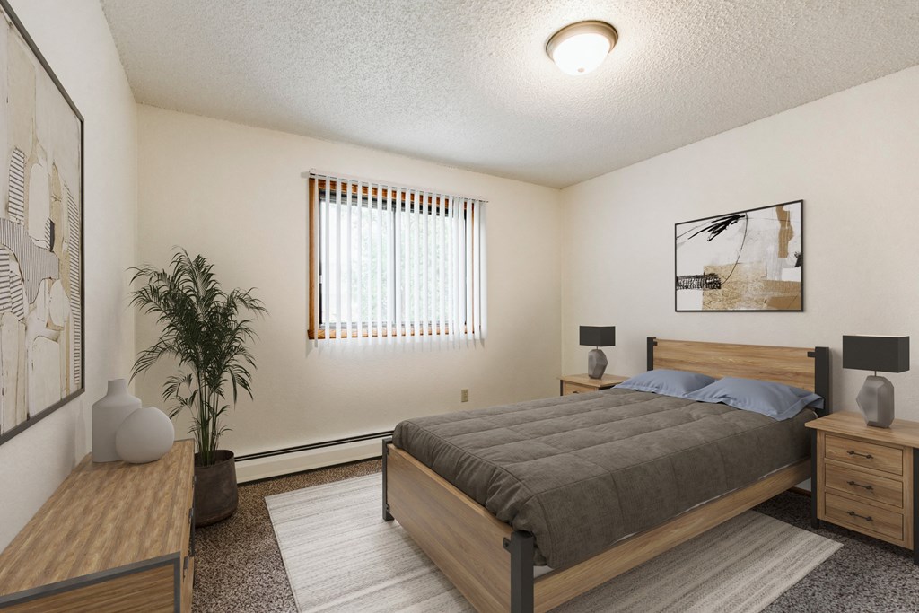 Grand Forks, Chandler 1802 Apartments. A bedroom with a bed and two nightstands with a window