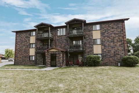 a brick apartment building with two balconies and a bike parked outside
