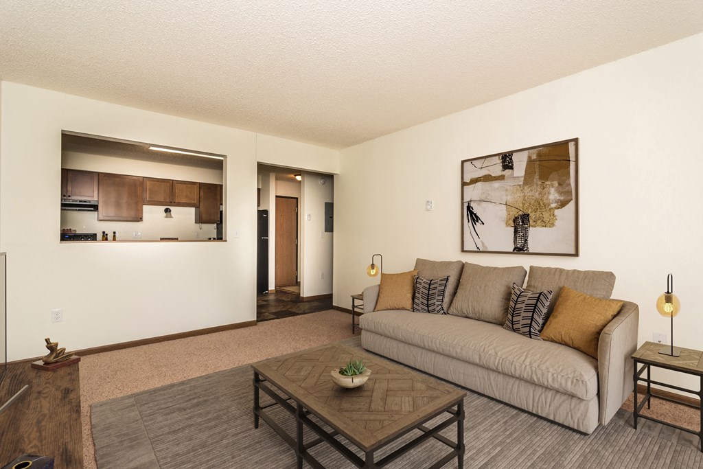 a living room with a couch and a coffee table. Grand Forks, ND Chandler 1898 Apartments