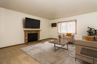 Grand Forks, ND Columbia West Apartments a living room with a fireplace and a tv - Photo Gallery 5