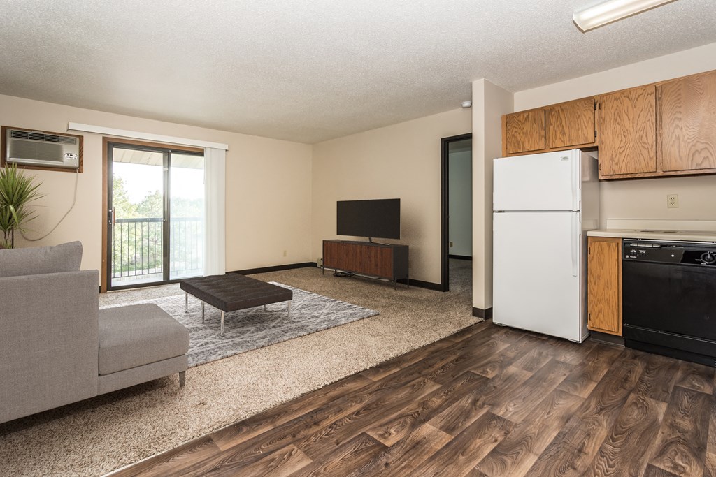 Grand Forks, ND Columbia West Apartments a living room with a white refrigerator freezer next to a stove top oven