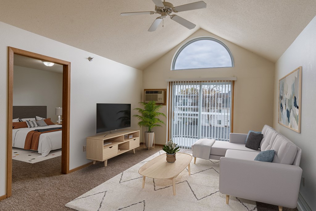 a living room with a couch and a tv and a bedroom. Grand Forks, ND Creekside Apartments.