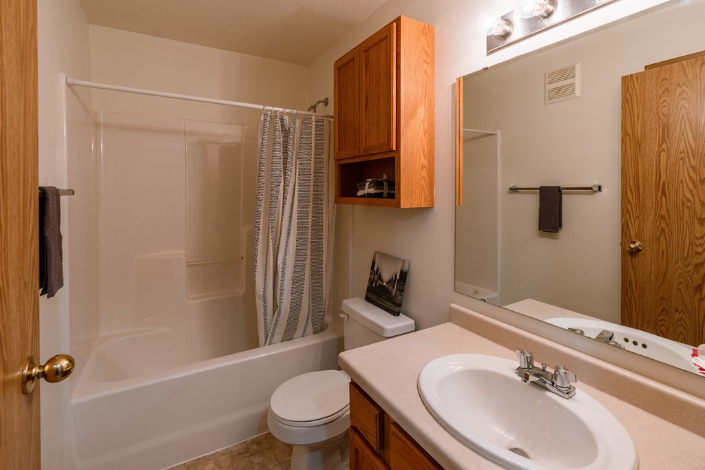 Grand Forks, ND Creekside Apartments. A bathroom with a sink and a toilet and a shower