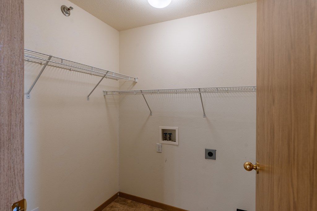Grand Forks, ND Creekside Apartments. A closet with two shelves and laundry hookups