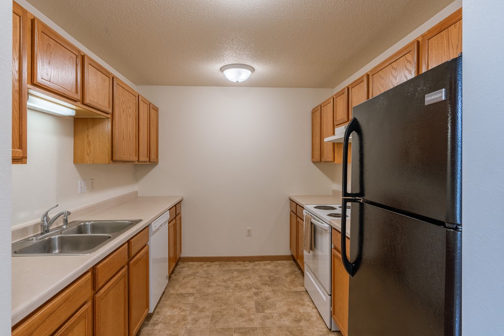 Grand Forks, ND Creekside Apartments. A kitchen with a refrigerator and a sink