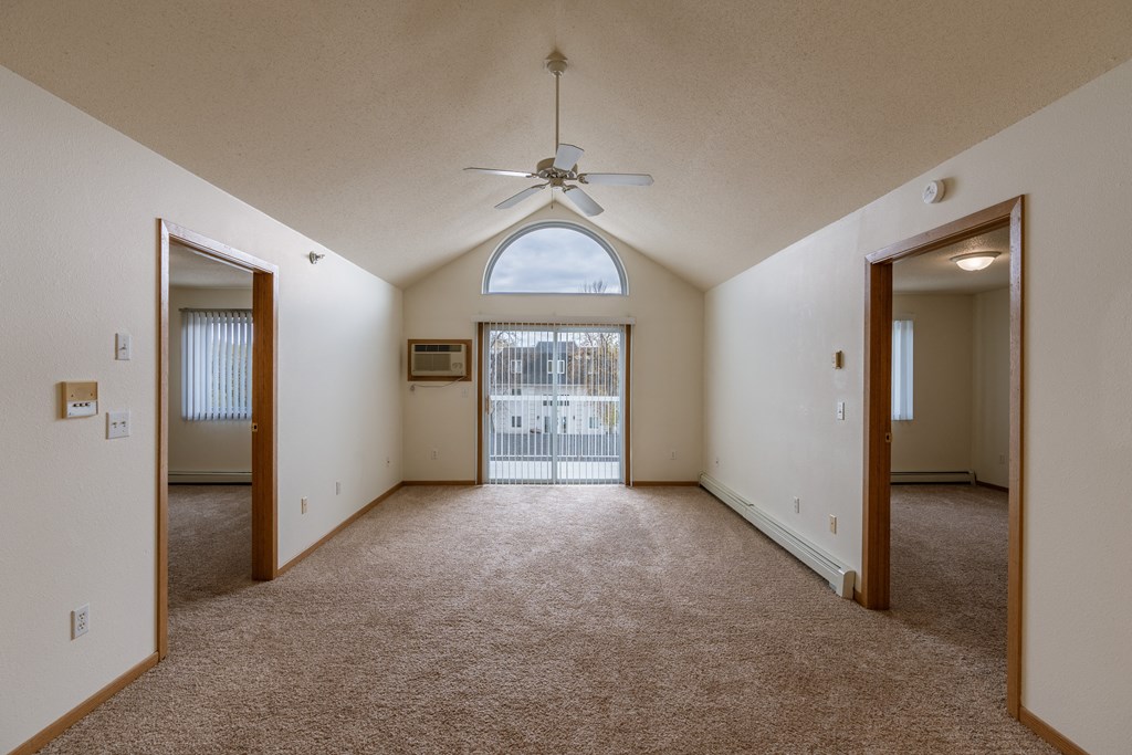 Grand Forks, ND Creekside Apartments. A living room with a ceiling fan and a balcony