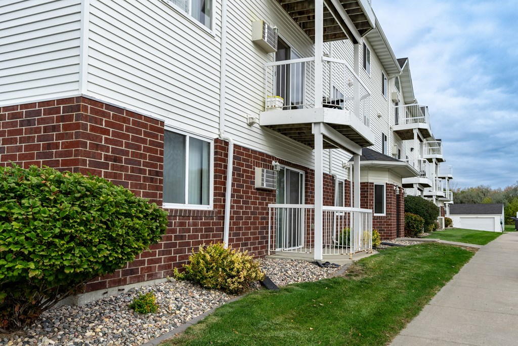 Grand Forks, ND Creekside Apartments. A brick and white building with a sidewalk in front of it