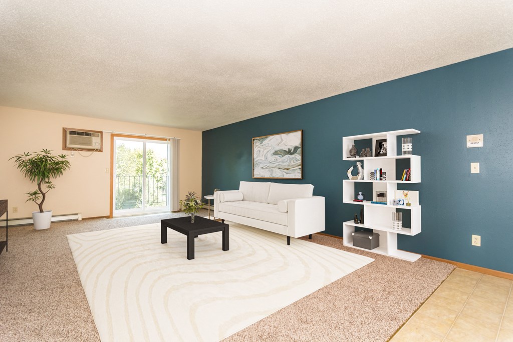 Grand Forks, ND Grandview I Apartments. a living room with a blue wall and a white couch and coffee table