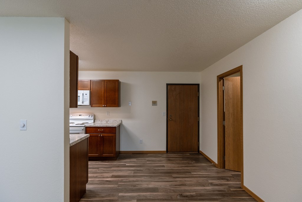 Grand Forks, ND Grandview Apartments, A dining room with a kitchen to the left, entry door, and a closet to the right.