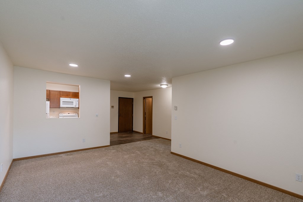 Grand Forks, ND Grandview Apartments. A living room with the kitchen and entry door in the background.