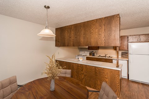 a kitchen and dining area with a wooden table and chairs