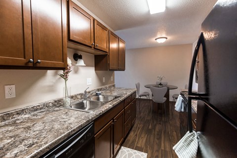 Grand Forks, ND Library Lane Apartments a kitchen with brown cabinets and granite countertops