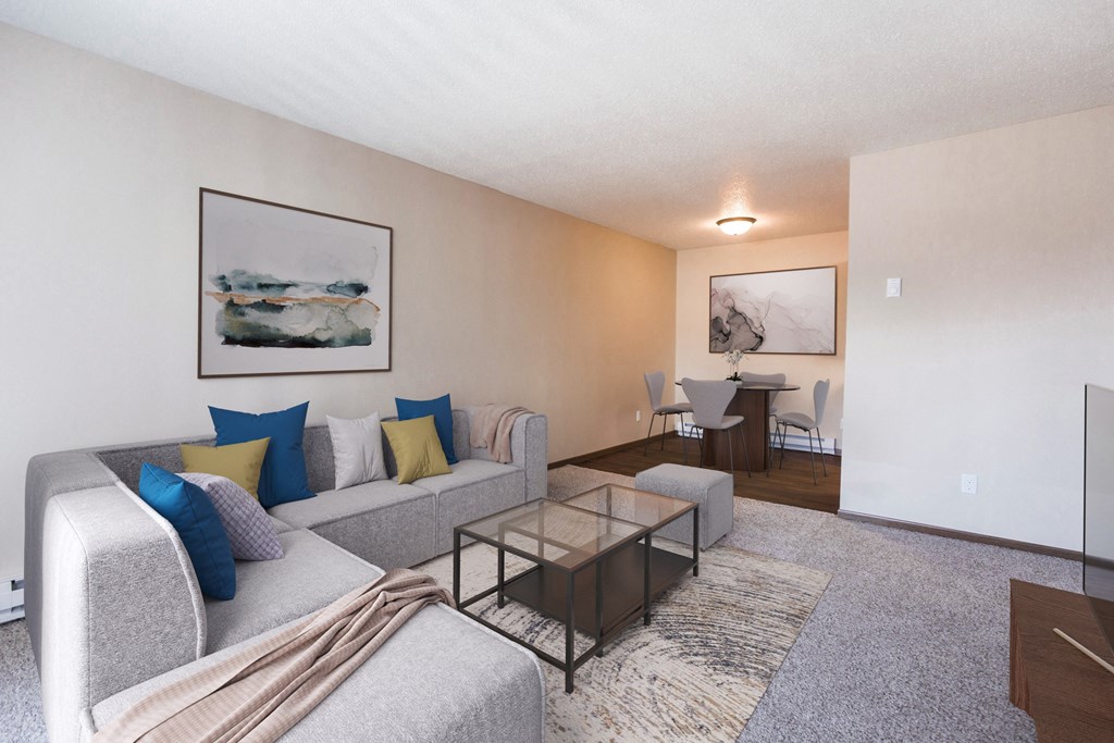 Grand Forks, ND Library Lane Apartments a living room with a couch coffee table and dining room table in the background